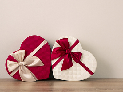 Two contrast coloured gift boxes for holiday on wooden surface.